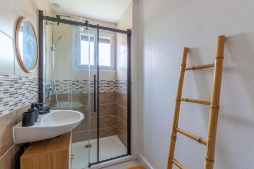 y baño con lavabo y ducha. en Gîte Renardeau - Maison à deux pas du centre ville en Carentan