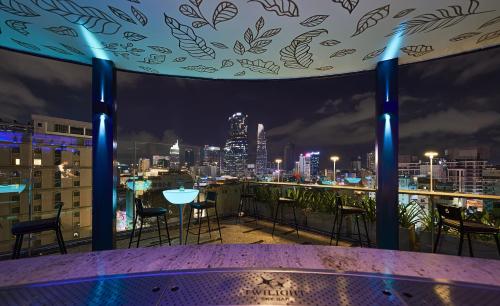 a rooftop bar with a view of the city at night at La Siesta Premium Saigon in Ho Chi Minh City