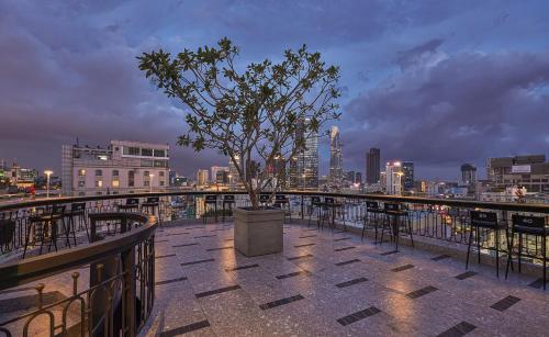 a tree on a balcony with a city skyline at La Siesta Premium Saigon in Ho Chi Minh City