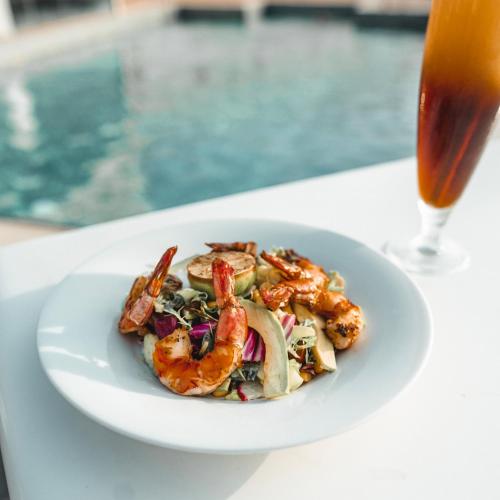 a plate of food on a table with a drink at Golden Tulip Muscat in Muscat