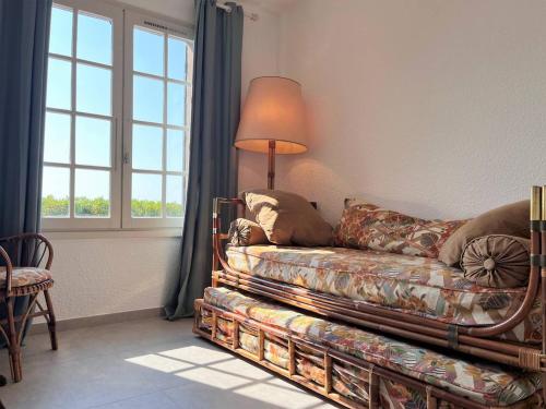 um sofá numa sala de estar com um candeeiro e uma janela em Maison Le Lavandou, 3 pièces, 6 personnes - FR-1-251-502 em Le Lavandou