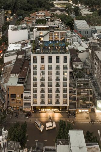 an overhead view of a large white building in a city at La Siesta Premium Saigon in Ho Chi Minh City