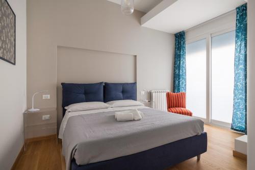 um quarto com uma cama azul e uma cadeira vermelha em Giusà by DomuSicily em Palermo