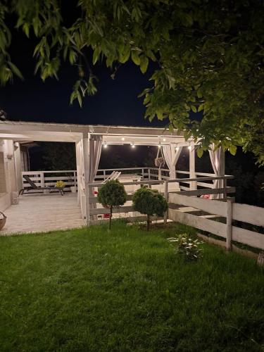 a deck at night with a fence and lights at Koperkowy Raj Beskid Wyspowy Domek Małopolska Jacuzzi Playroom in Laskowa