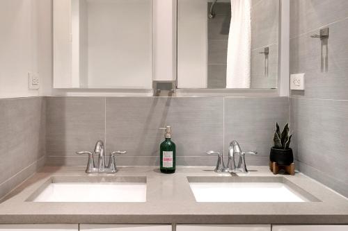 La salle de bains est pourvue de 2 lavabos et d'une bouteille de vin. dans l'établissement 3 BR in Upper West Side, à New York