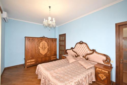 a bedroom with a bed and a chandelier at Homestay at City Center in Yerevan