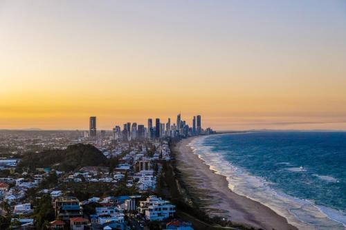 a view of a city and the beach at sunset at Burleigh Surf Apartments in Gold Coast