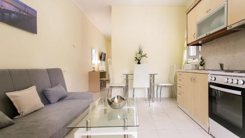 a living room with a couch and a table at Tranquil Apartments Corfu in Kontokali