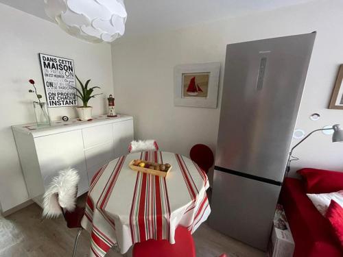 une cuisine avec une table et un réfrigérateur dans l'établissement Charmant appartement à 50m de la plage avec terrasse, parking privé et balcon aménagé - FR-1-413-216, à Capbreton