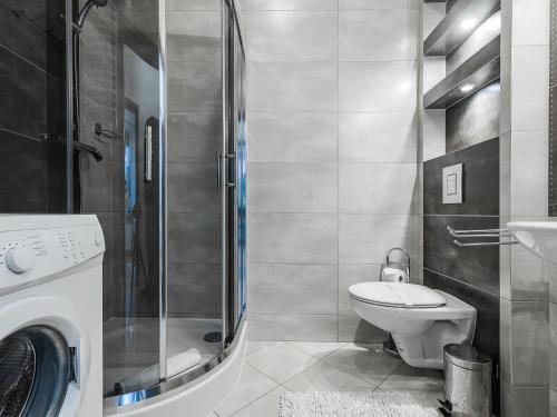 y baño con aseo, lavabo y ducha. en VisitZakopane - Aquapark Residence One Apartment, en Zakopane
