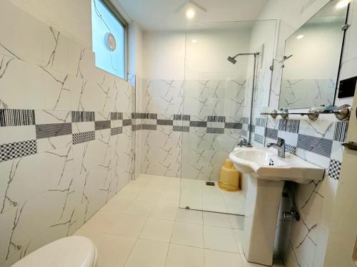 a bathroom with a sink and a toilet and a shower at Desert One Hotel Skardu in Skardu