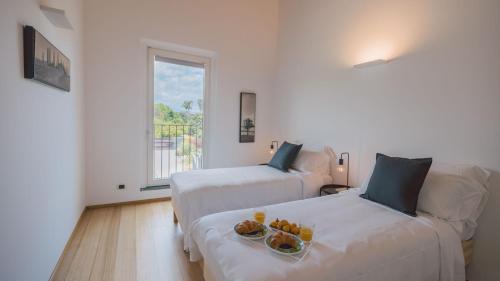 a hotel room with two beds with a tray of food at VILLA KIMIA 8, Emma Villas in Acireale