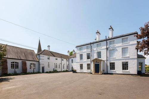 a group of white buildings with a large parking lot at South Wing of Edwinstowe Hall in Edwinstowe