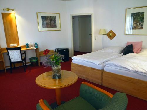 Habitación de hotel con 2 camas, mesa y sillas en Hotel-Nachtwächter, en Unna