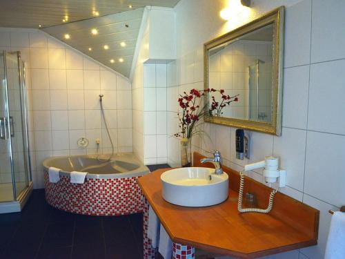a bathroom with a sink and a bath tub at Hotel-Nachtwächter in Unna