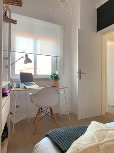 a bedroom with a desk with a laptop and a chair at Lisbon, renovated T2 apartment Portas de Benfica in Amadora