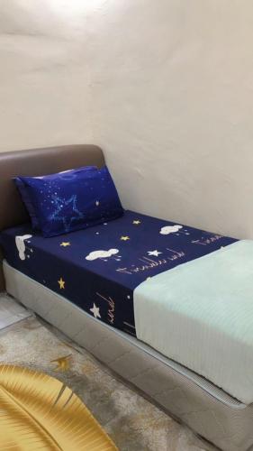 ein Bett mit blauer Bettwäsche und einem blauen Kissen in der Unterkunft MZ Homestay in Kuala Rompin