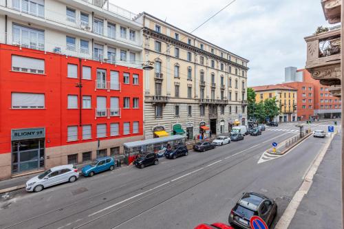 a busy city street with cars parked on the street at Easylife - Oasi urbana in zona Bocconi in Milan