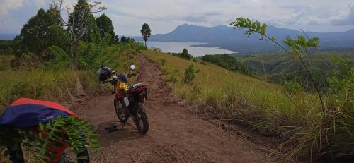 a person riding a bike on a dirt road at 4 Pohon - Les 4 Arbres in Pandang