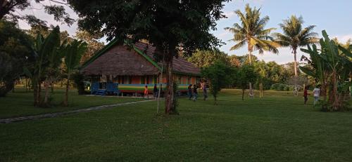a group of people walking around a park with a building at 4 Pohon - Les 4 Arbres in Pandang