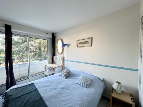 a bedroom with a bed and a large window at Appartement bord de mer, Bénodet in Bénodet