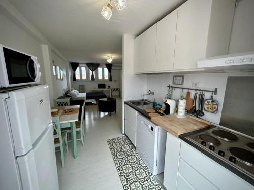 a kitchen with a white refrigerator and a table at La Roma di Camilla in Rome