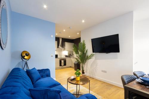 a living room with a blue couch and a tv at At the level - (2 bed flat) in Brighton & Hove