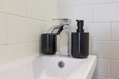 ein Waschbecken mit einem Haartrockner und einem Wasserhahn in der Unterkunft At the level - (2 bed flat) in Brighton & Hove