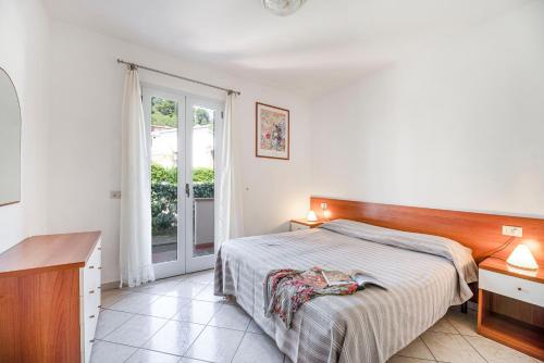 a bedroom with a bed and a desk and a window at Appartamenti Casa Dini in Marina di Campo