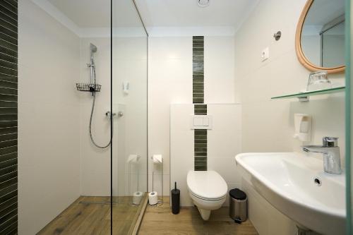 a bathroom with a shower and a toilet and a sink at ROOMS in Szombathely