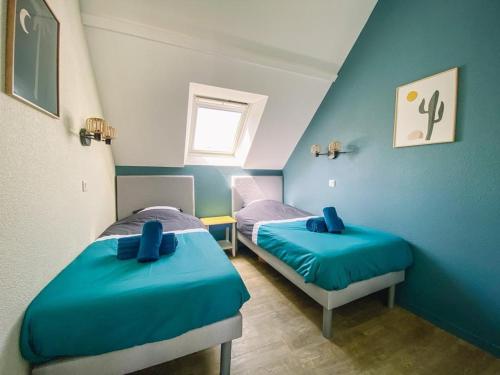 - 2 lits dans une chambre aux murs bleus dans l'établissement Appartement en duplex front de mer, Cap Coz, à Fouesnant