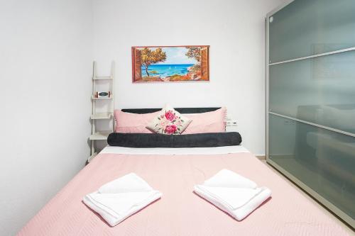 a bedroom with a pink bed with two pillows at Penelope Downtown in Skiathos