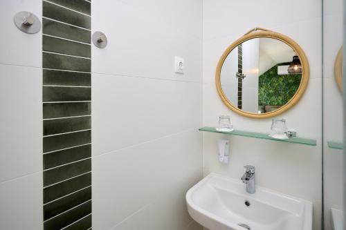 a bathroom with a sink and a mirror at ROOMS in Szombathely