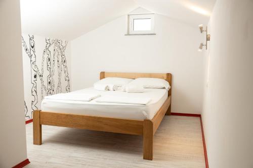 a small bedroom with a bed with white sheets at Smiley 2 in Novalja