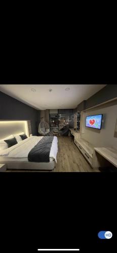 een slaapkamer met een groot bed en een flatscreen-tv bij Özkan rezidans dairesi in Kartepe
