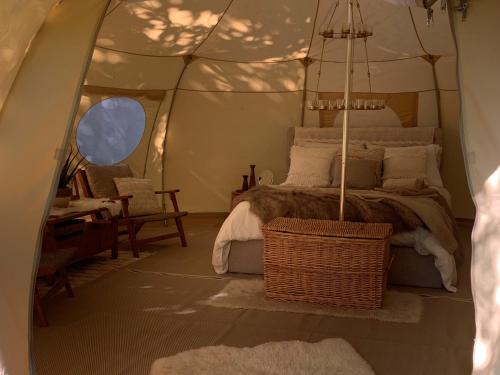 ein Schlafzimmer mit einem Bett in einem Zelt in der Unterkunft The Glade Bell tent in Sarcé
