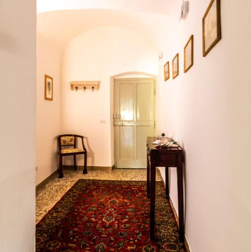 a hallway with a rug and a table and a door at La Semplicità del Borgo in Bagnoregio
