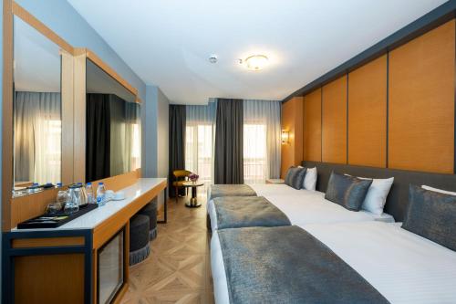 イスタンブールにあるFreya Hotelのベッド2台と鏡が備わるホテルルームです。