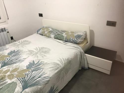 1 dormitorio con 1 cama con colcha de temática vegetal en A Chic Four-Person Apartment By The Beach At Cap Ras, en Llançà