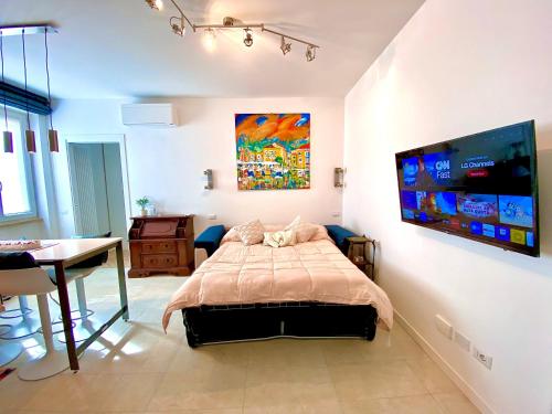 a bedroom with a bed and a table and a tv at Appartamento Alice Silver in Bardolino