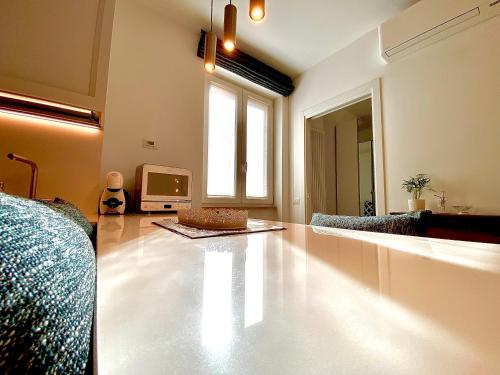 a living room with a large white floor and a television at Appartamento Alice Silver in Bardolino