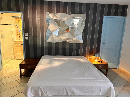 ein Schlafzimmer mit einem weißen Bett und einer Wand in der Unterkunft Dans Bâtisse traditionnelle appartement de la plage et terrasse Bali in Rayol-Canadel-sur-Mer