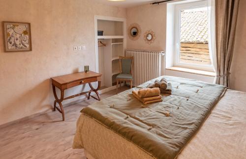 a bedroom with a bed and a desk and a window at chambres d hotes Ysalice in Merlas