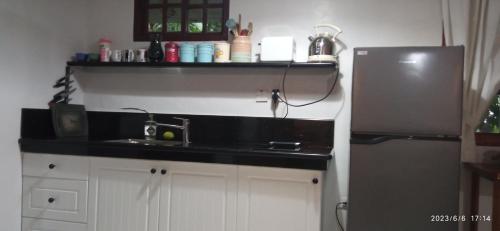 a kitchen with a sink and a refrigerator at Dulangan Puerto Galera Transient Place in Puerto Galera