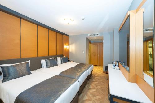 duas camas num quarto de hotel com uma cruz na parede em Freya Hotel em Istambul