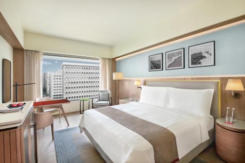 a hotel room with a large bed and a desk at Trident Nariman Point in Mumbai