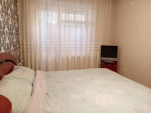 ein kleines Schlafzimmer mit einem Bett und einem TV in der Unterkunft Трьохкімнатна квартира неподалік центру in Ternopil