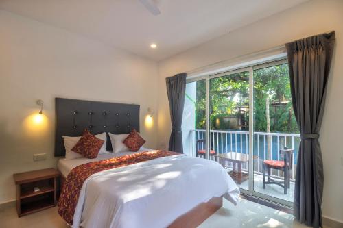 バガにあるAmazing 2BHK Apartment Near Baga Beachのベッドとバルコニーのある寝室