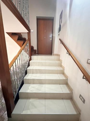 a staircase in a house with a wooden door at La Casetta Guest House in San Giorgio a Cremano