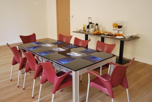 a dining room with a table and red chairs at Estudiotel Alicante in Alicante